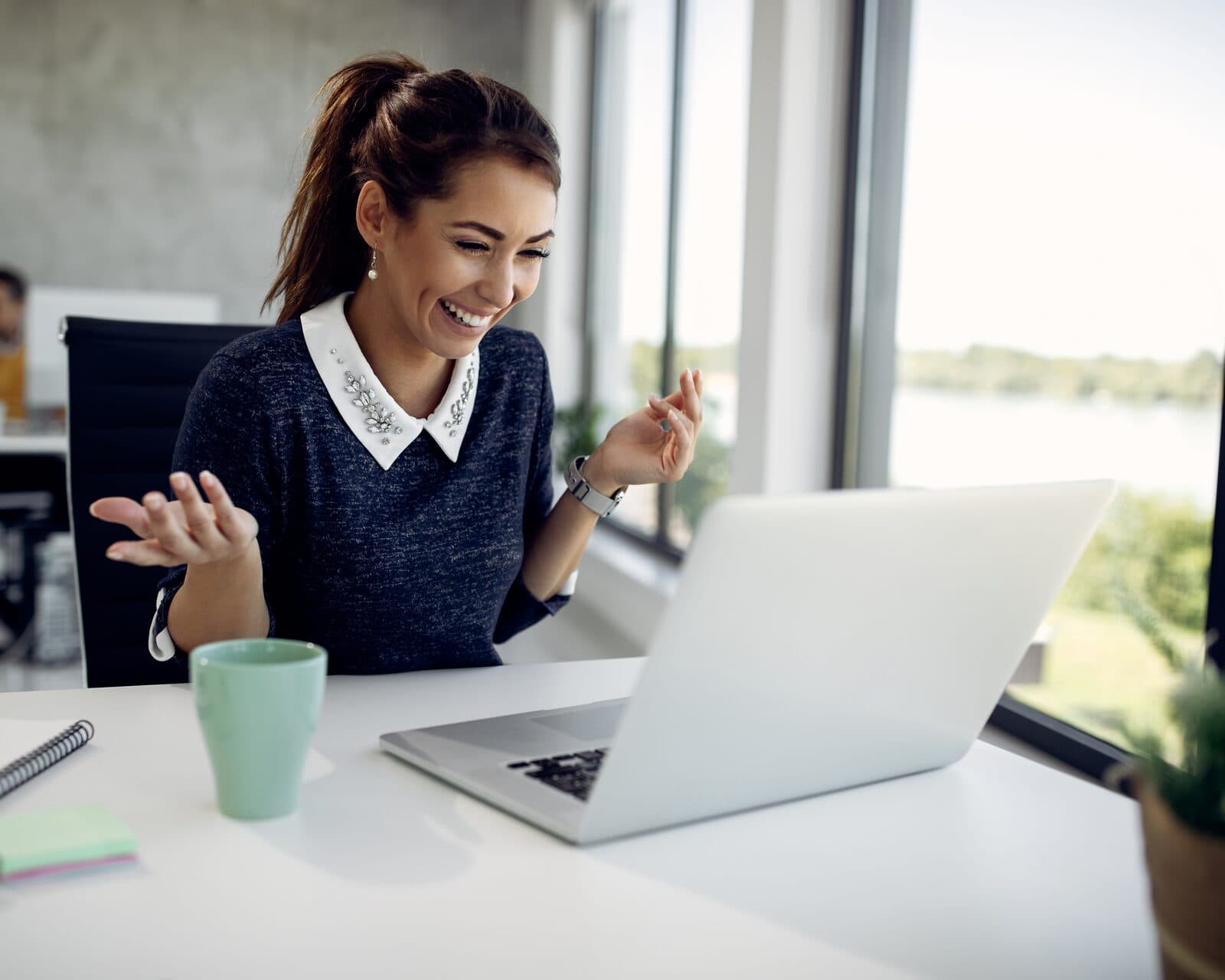 A young woman at her laptop rehearses a conversation out loud